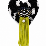 Handmade tufted brooch in black and white with beaded evil eye embellishment, chartreuse green fringe and pearl drop charm