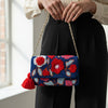 Colorful embroidered handbag held by a person in a neutral setting