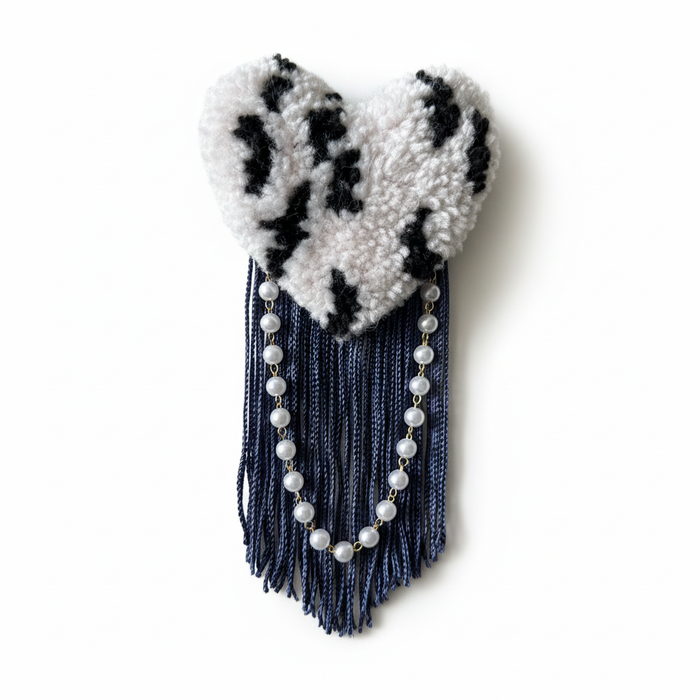 Black and white zebra-striped tufted heart brooch with one pearl strand