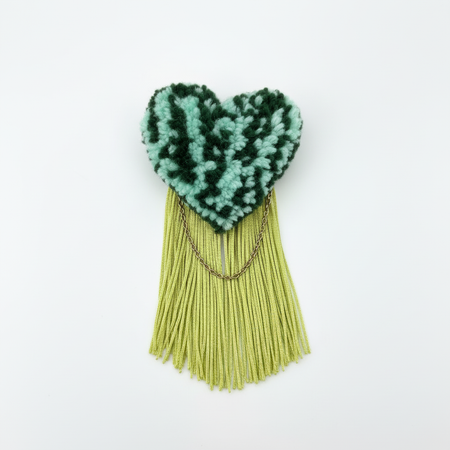 Centered studio photo of handmade tufted brooch