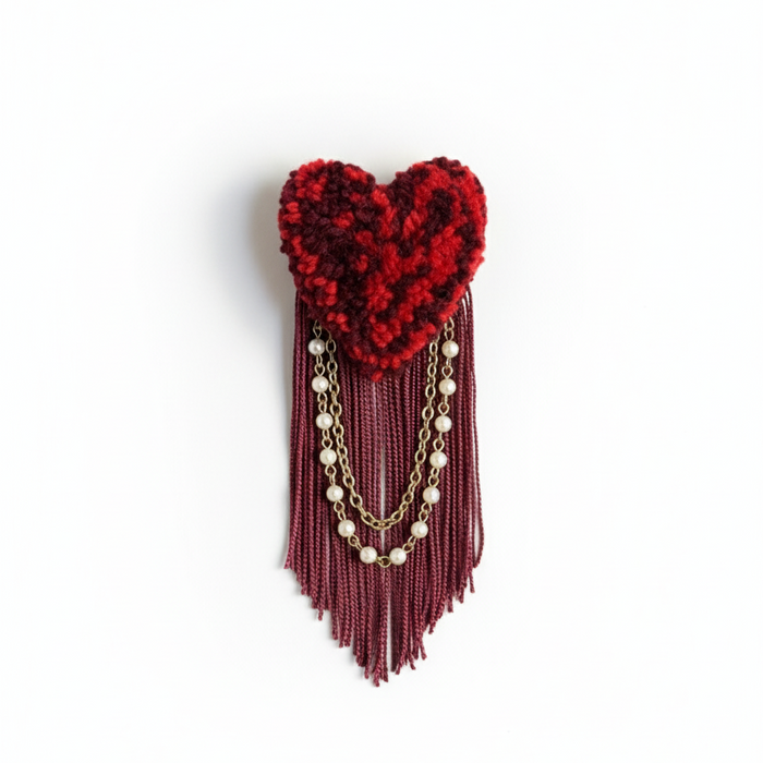 Clean minimal product photo of burgundy heart brooch with pearl chains