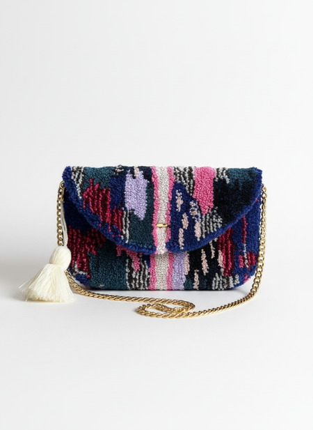 Clean studio product photo of hand-tufted clutch