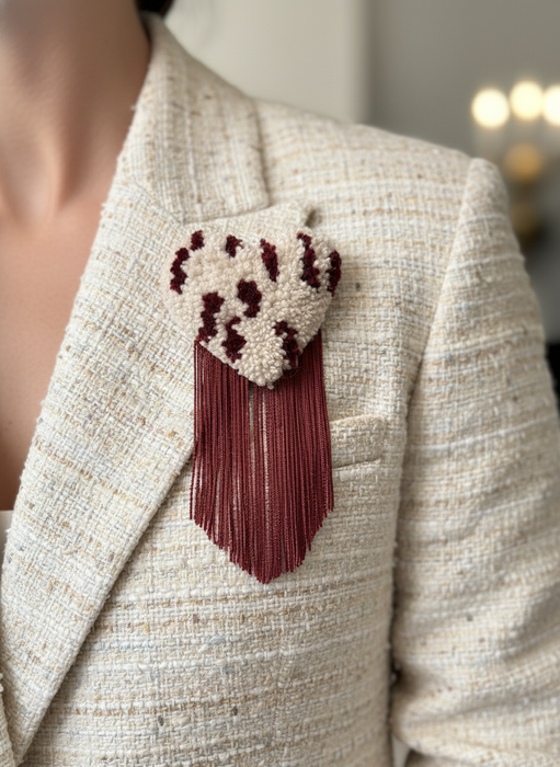 Editorial photo of model wearing polka dot brooch on cream tweed blazer
