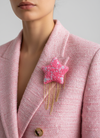 Editorial photo of pink confetti star brooch on pink tweed blazer