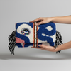 Hands holding oversized clutch - larger scale