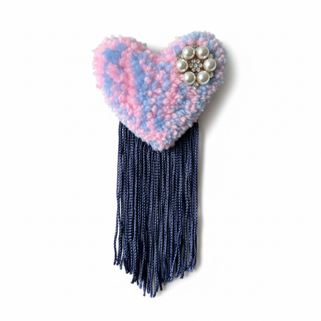 Professional product photo of pink and blue tufted heart brooch with navy fringe